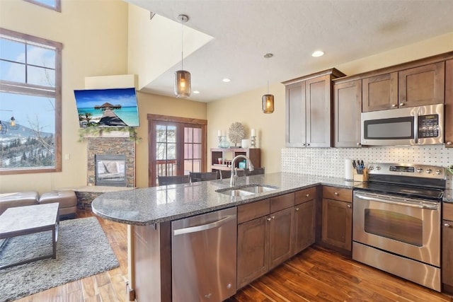 0050 County Road 1293 Unit B, Silverthorne, CO 80498 - kitchen with dark stone countertops, a sink, stainless steel appliances, dark wood finished floors, and a peninsula