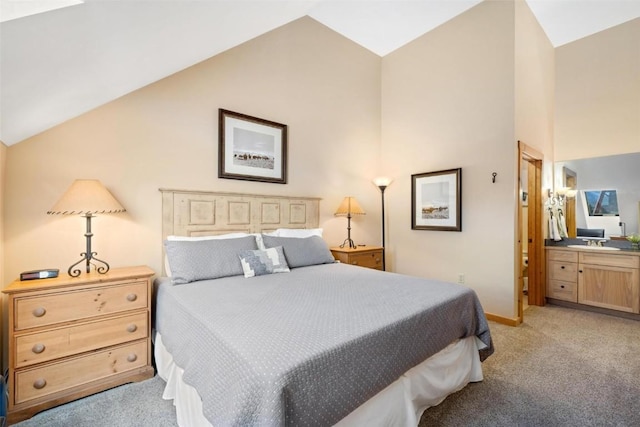bedroom featuring ensuite bath, baseboards, high vaulted ceiling, and light colored carpet