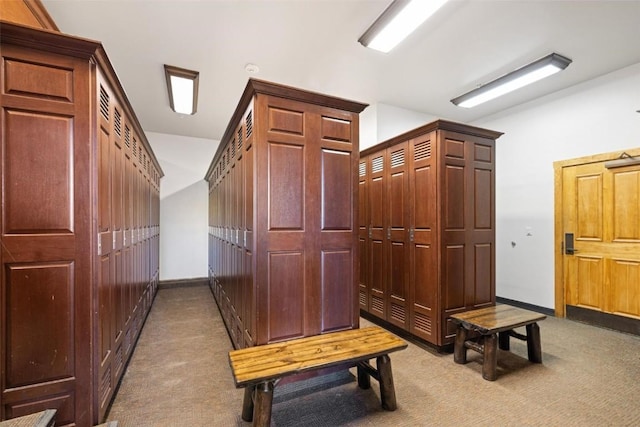 mudroom with baseboards and dark colored carpet