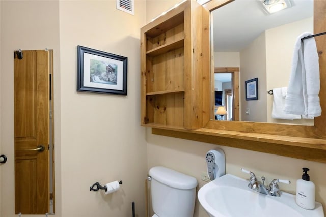 bathroom featuring visible vents, a sink, and toilet