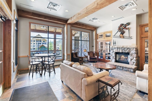 living area featuring beamed ceiling and visible vents