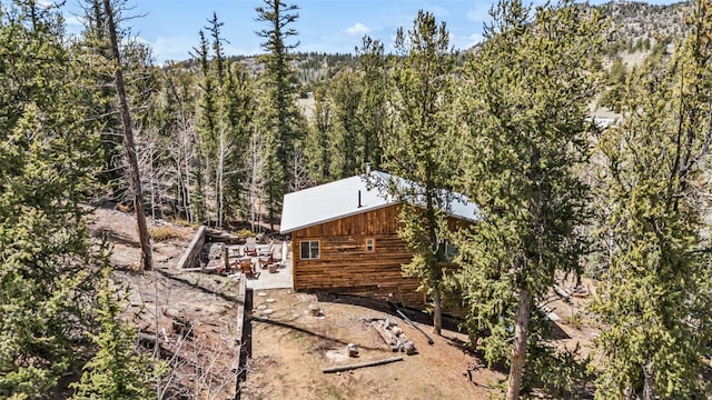 view of property exterior with a forest view
