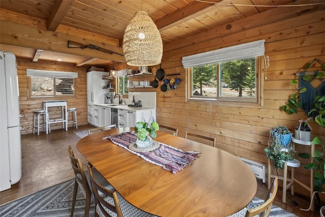 433 Fremont Knoll Ln, Jefferson, CO 80456 - dining area featuring wood walls, a baseboard radiator, wooden ceiling with exposed beams, and dark wood-style flooring