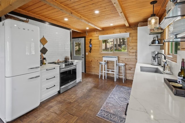433 Fremont Knoll Ln, Jefferson, CO 80456 - kitchen featuring freestanding refrigerator, stainless steel range with electric cooktop, wood ceiling with exposed beams, a sink, and open shelves