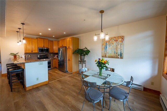 580 Anglers Dr Unit 204, Steamboat Springs, CO 80487 - kitchen featuring stainless steel appliances, a peninsula, a sink, a breakfast bar, and light wood-style floors