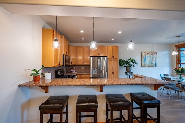 580 Anglers Dr Unit 204, Steamboat Springs, CO 80487 - kitchen with appliances with stainless steel finishes, decorative backsplash, a peninsula, light stone counters, and recessed lighting