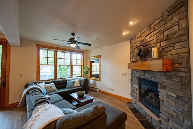 580 Anglers Dr Unit 204, Steamboat Springs, CO 80487 - living area with a baseboard radiator, a fireplace, a ceiling fan, and baseboards