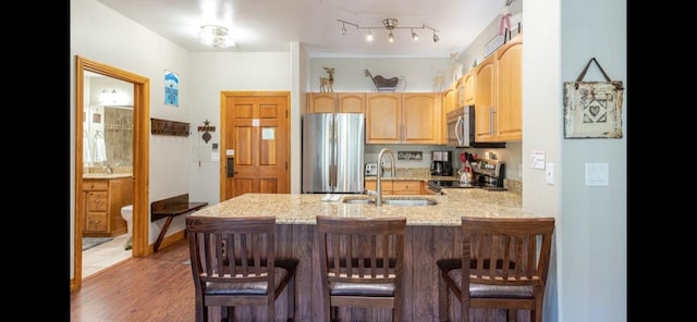 22714 US Highway 6 Unit 5989, Keystone, CO 80435 - kitchen with light brown cabinets, a sink, a peninsula, appliances with stainless steel finishes, and light stone countertops