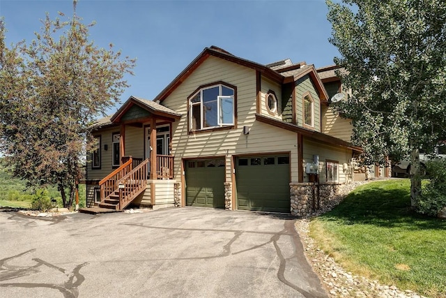 631 Parkview Dr, Steamboat Springs, CO 80487 - view of front of house featuring a garage, driveway, a front yard, and stone siding