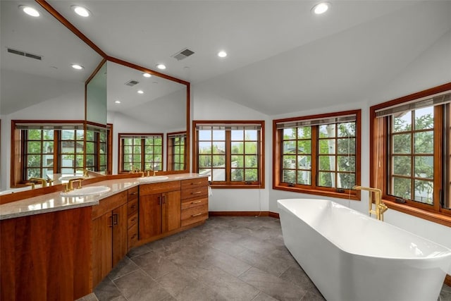 2600 Eagleridge Dr Unit 26, Steamboat Springs, CO 80487 - bathroom with plenty of natural light, double vanity, baseboards, a soaking tub, and vaulted ceiling