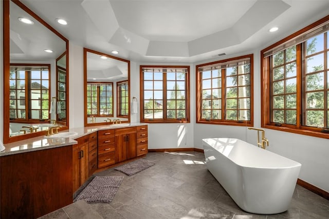 2600 Eagleridge Dr Unit 26, Steamboat Springs, CO 80487 - full bathroom with baseboards, double vanity, a soaking tub, a tray ceiling, and recessed lighting