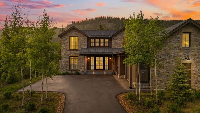 628 Independence Rd, Keystone, CO 80435 - view of front of house featuring stone siding, a standing seam roof, driveway, and a metal roof