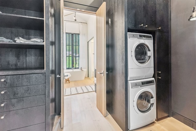 628 Independence Rd, Keystone, CO 80435 - laundry area with stacked washer / drying machine, wood finished floors, and cabinet space