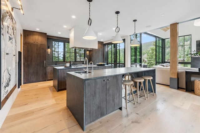 628 Independence Rd, Keystone, CO 80435 - kitchen featuring a center island with sink, dark countertops, modern cabinets, light wood-type flooring, and recessed lighting