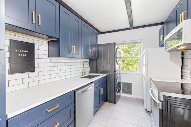 8011 Ryan Gulch Rd Unit B2, Silverthorne, CO 80498 - kitchen featuring appliances with stainless steel finishes, blue cabinets, tasteful backsplash, light tile patterned flooring, and light stone countertops