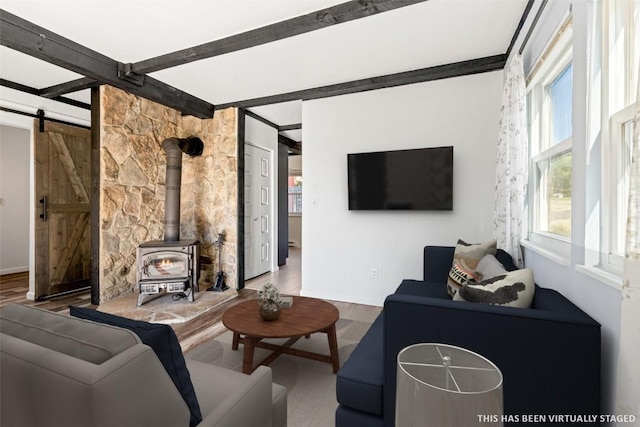 8011 Ryan Gulch Rd Unit B2, Silverthorne, CO 80498 - living room with a wood stove, a barn door, and beamed ceiling