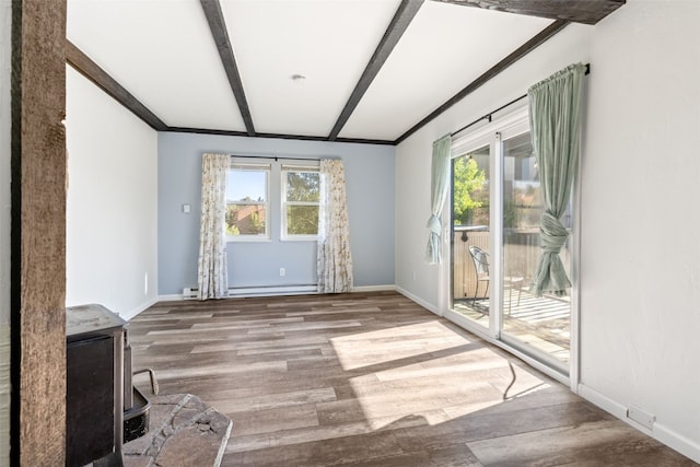8011 Ryan Gulch Rd Unit B2, Silverthorne, CO 80498 - unfurnished room with wood finished floors, beamed ceiling, and a wood stove
