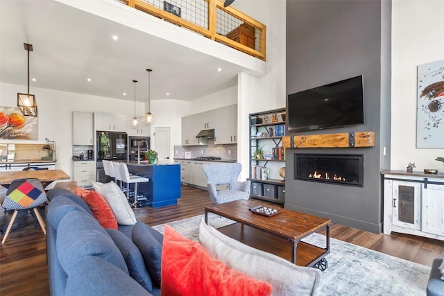 581 Fairview Blvd, Breckenridge, CO 80424 - living area featuring dark wood-style floors, a glass covered fireplace, a towering ceiling, beverage cooler, and recessed lighting