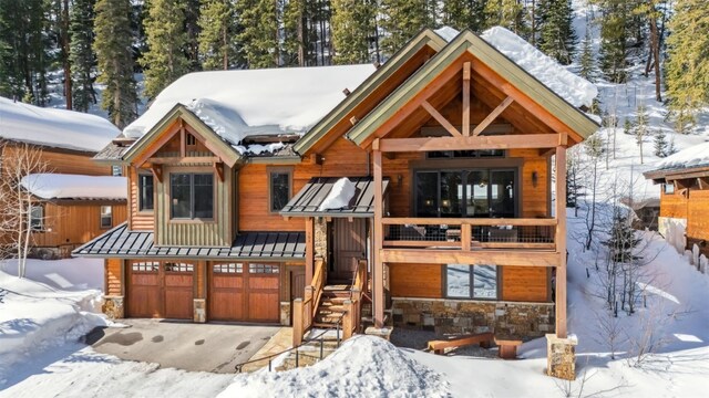 103 Victory Ln, Breckenridge, CO 80424 - view of front facade featuring stone siding, a standing seam roof, driveway, and a garage