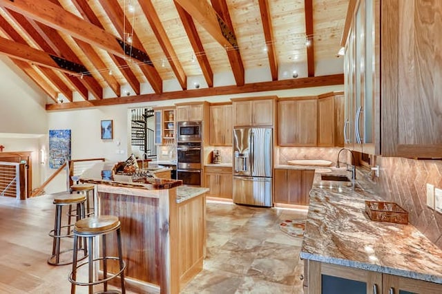 103 Victory Ln, Breckenridge, CO 80424 - kitchen featuring stainless steel appliances, a kitchen breakfast bar, a sink, tasteful backsplash, and beamed ceiling