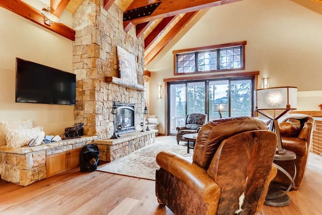 103 Victory Ln, Breckenridge, CO 80424 - living room with high vaulted ceiling, beam ceiling, a stone fireplace, and light wood-type flooring