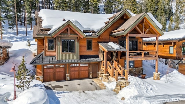 103 Victory Ln, Breckenridge, CO 80424 - view of front facade with an attached garage, driveway, stone siding, and stairs