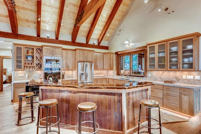 103 Victory Ln, Breckenridge, CO 80424 - kitchen featuring stainless steel appliances, a breakfast bar, a sink, a center island, and decorative backsplash