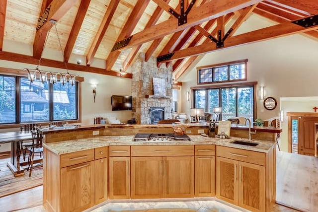 103 Victory Ln, Breckenridge, CO 80424 - kitchen with a sink, open floor plan, stainless steel gas stovetop, a stone fireplace, and high vaulted ceiling