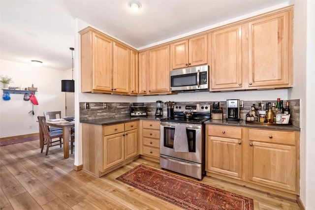 32404 Ute Trl, Oak Creek, CO 80467 - kitchen featuring dark countertops, appliances with stainless steel finishes, light wood-style floors, light brown cabinets, and baseboards