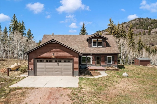 32404 Ute Trl, Oak Creek, CO 80467 - view of front of home featuring an attached garage, a storage shed, a front yard, an outbuilding, and concrete driveway