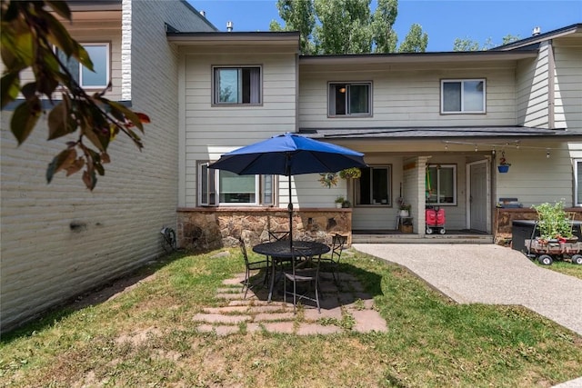 4 Sequoia Ct, Steamboat Springs, CO 80487 - rear view of property featuring a patio area, stone siding, a fire pit, and a lawn