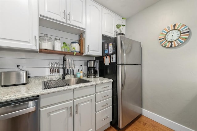 4 Sequoia Ct, Steamboat Springs, CO 80487 - kitchen with stainless steel appliances, white cabinetry, light wood-style flooring, and light stone counters
