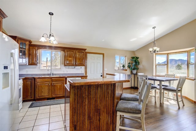 526 Sharps Way, Como, CO 80456 - kitchen featuring a chandelier, a sink, white fridge with ice dispenser, vaulted ceiling, and a kitchen breakfast bar