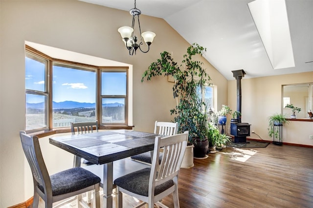 526 Sharps Way, Como, CO 80456 - dining room with vaulted ceiling, a wood stove, wood finished floors, a chandelier, and a mountain view