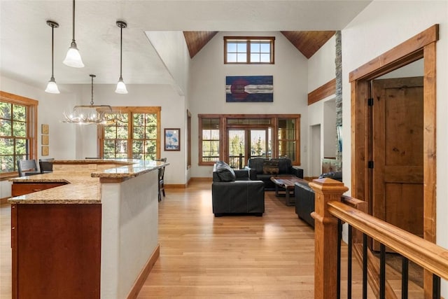 50 Cooney Ct, Blue River, CO 80424 - kitchen featuring light wood-style flooring, light stone countertops, hanging light fixtures, a chandelier, and lofted ceiling