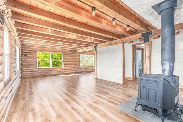 30955 Whitecotton Ct, Steamboat Springs, CO 80487 - unfurnished living room with a wood stove, wood-type flooring, beamed ceiling, and rustic walls