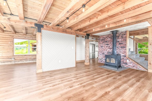 30955 Whitecotton Ct, Steamboat Springs, CO 80487 - unfurnished living room featuring a wood stove, wood ceiling with exposed beams, wood finished floors, stairs, and rail lighting