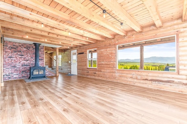 30955 Whitecotton Ct, Steamboat Springs, CO 80487 - unfurnished living room with a wood stove, wood ceiling with exposed beams, wood-type flooring, rail lighting, and a mountain view