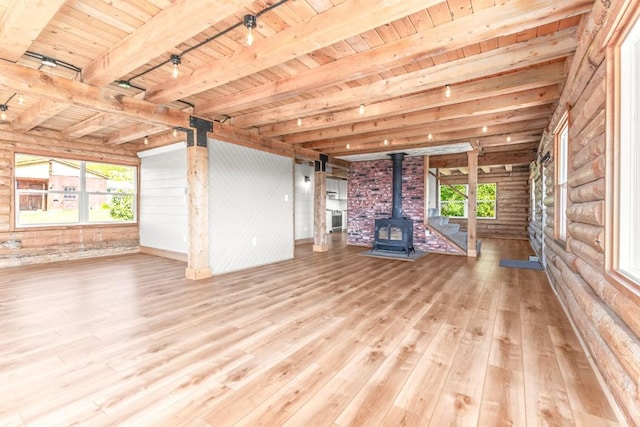 30955 Whitecotton Ct, Steamboat Springs, CO 80487 - unfurnished living room featuring a wood stove, wooden ceiling with exposed beams, wood finished floors, and rail lighting