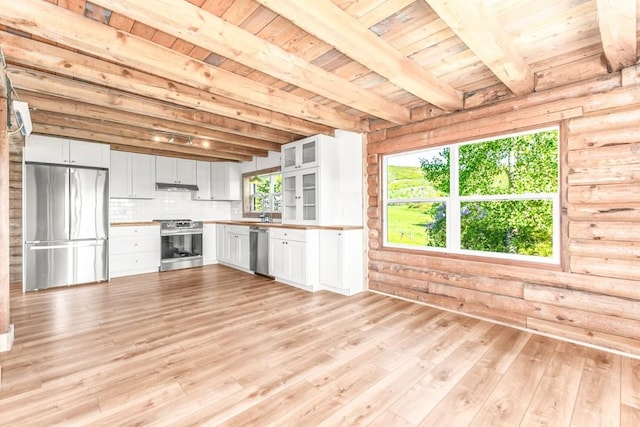 30955 Whitecotton Ct, Steamboat Springs, CO 80487 - kitchen featuring appliances with stainless steel finishes, wooden ceiling with exposed beams, under cabinet range hood, light wood-style floors, and light countertops