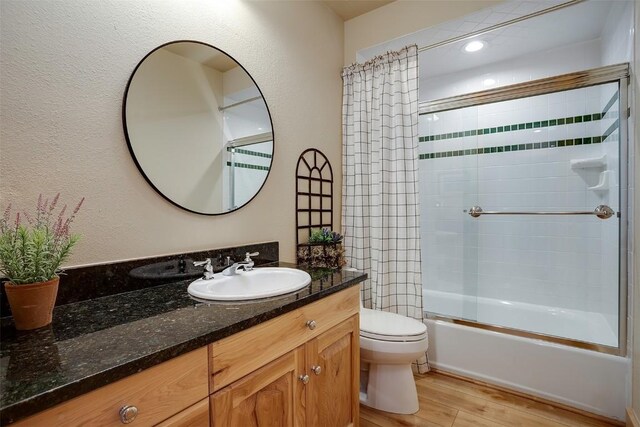 1064 Steamboat Blvd, Steamboat Springs, CO 80487 - bathroom with shower / bath combination with glass door, wood finished floors, toilet, and vanity