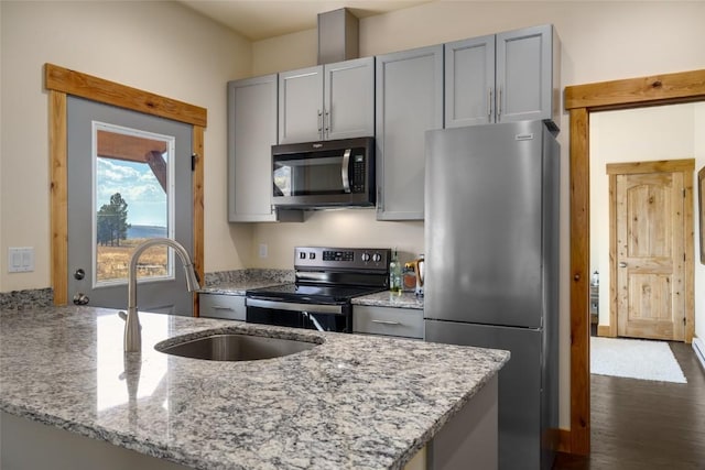 kitchen featuring gray cabinetry, sink, light stone countertops, appliances with stainless steel finishes, and kitchen peninsula