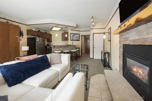 45 Beeler Pl Unit 301, Copper Mountain, CO 80443 - living area featuring light carpet, a stone fireplace, a textured ceiling, and track lighting