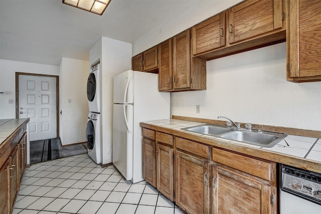 716 Lagoon Dr Unit D, Frisco, CO 80443 - kitchen with freestanding refrigerator, tile counters, stacked washer and clothes dryer, and a sink