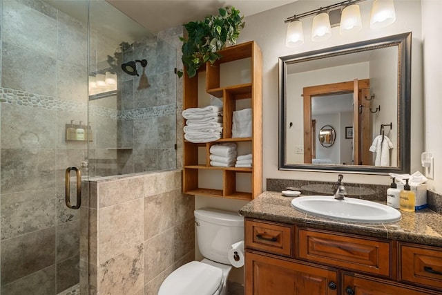 bathroom featuring an enclosed shower, vanity, and toilet