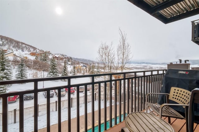 snow covered back of property featuring a mountain view