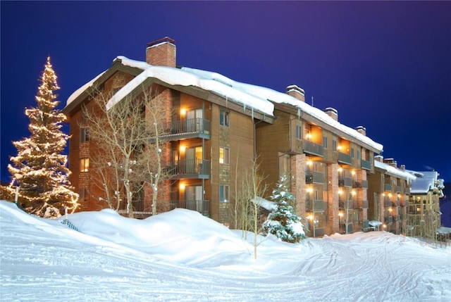 view of snow covered exterior with a chimney