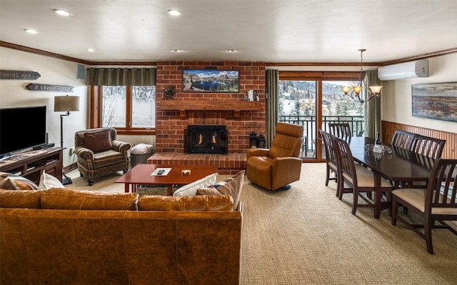 carpeted living room featuring crown molding, a fireplace, a wall unit AC, and a notable chandelier