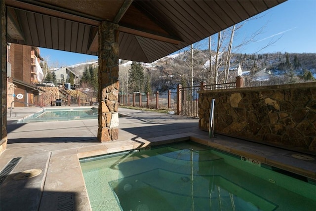 view of pool featuring a hot tub and a mountain view