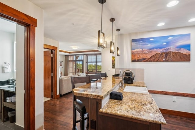 1521 Ski Hill Rd Unit 8312, Breckenridge, CO 80424 - kitchen with dark wood-style floors, a breakfast bar area, light stone counters, a peninsula, and recessed lighting